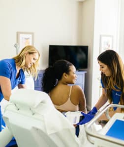 Woman in treatment behind two staff