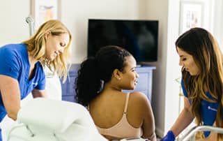 Woman in treatment behind two staff